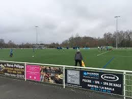 Image représentant un terrain de sport amateur avec de la publicité sur les gardes corps autour du terrain